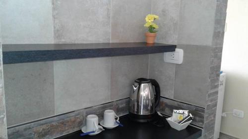 a kitchen counter with a tea kettle and cups on it at NEFERET Habitaciones Temporarias in Corrientes