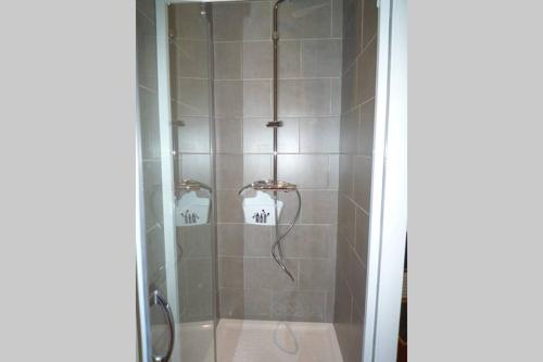 a shower with a glass door next to a shower at Le Clos 25 in Chalon-sur-Saône