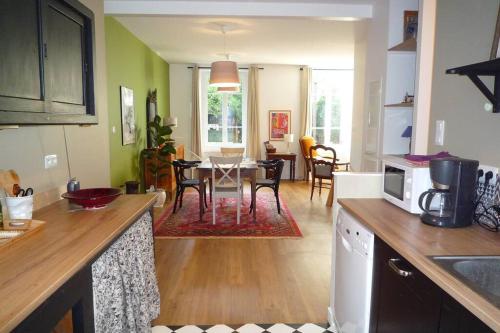 a kitchen and living room with a table and chairs at Le Clos 25 in Chalon-sur-Saône