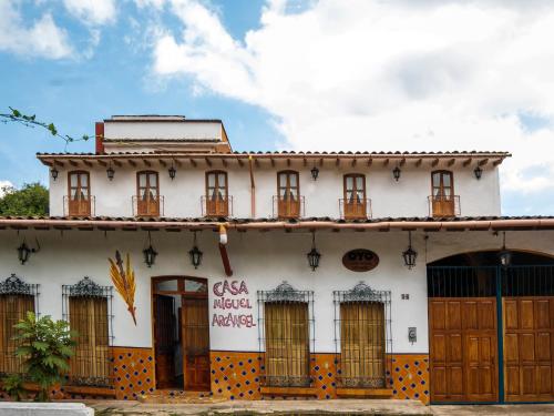 an old white building with wooden doors and windows at Casa Miguel Arcangel in Coatepec