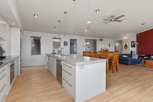 an open kitchen and living room with a dining room at Restful Ruakaka - Ruakaka Holiday Home in Ruakaka