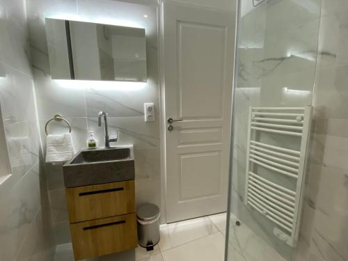 a white bathroom with a sink and a mirror at Le Charme - Au Coeur d'Agen - Self Checkin - Wifi - Netflix - Smart TV - Luqs fr in Agen