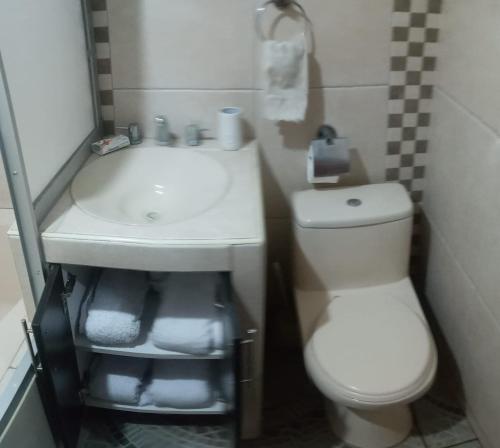 a bathroom with a white toilet and a sink at A un minuto del aeropuerto Siéntase como en casa in Cusco