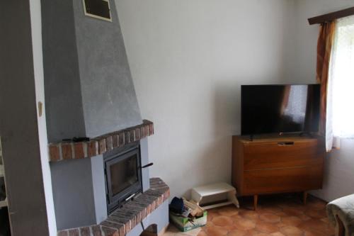 Una sala de estar con chimenea y TV de pantalla plana. en Chlalupa se zahradou - Chlum u Třeboně, en Chlum u Třeboně