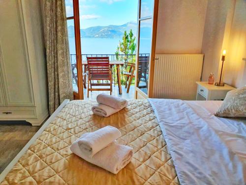 1 Schlafzimmer mit 2 Handtüchern auf einem Bett und einem Balkon in der Unterkunft Paleros View Inn in Palairos