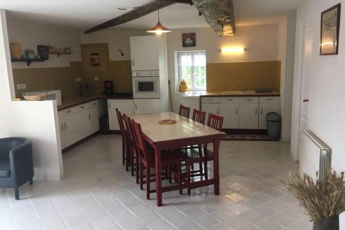 a kitchen with a wooden table and chairs in it at logement indépendant LE POULAILLER proche Guédelon in Treigny