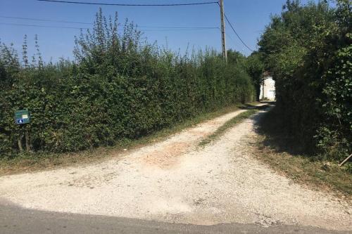 a dirt road with bushes on the side of a road at logement indépendant LE POULAILLER proche Guédelon in Treigny