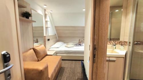 a small room with a bed and a couch and a sink at Angella KOP Konaci in Kopaonik