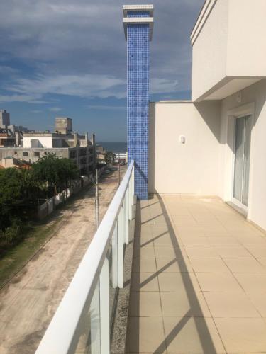 un balcón con una torre de azulejos azules en el lateral de un edificio en duplex mariscal, en Bombinhas