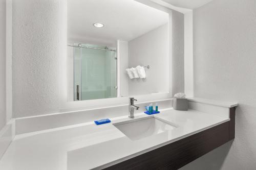 a white bathroom with a sink and a mirror at Holiday Inn Express Hotels & Suites Greenville-Spartanburg/Duncan by IHG in Duncan