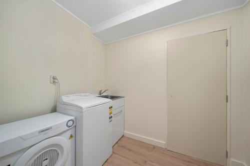 a laundry room with a washer and dryer at Wharerata - Otaki Beach Holiday Home in Otaki Beach