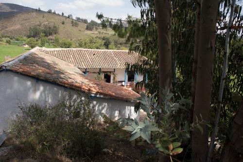 a house with a tile roof next to a building at Casa Campestre SUANOGA in Pesca