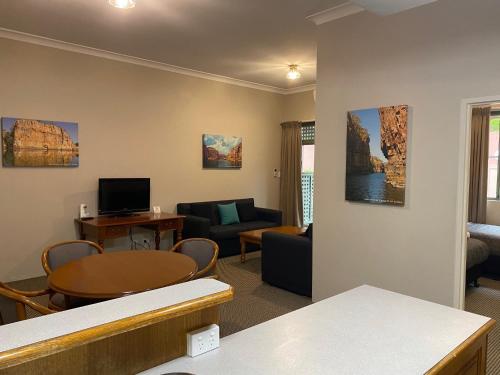 a living room with a table and a couch at The Belmore Apartments Hotel in Wollongong