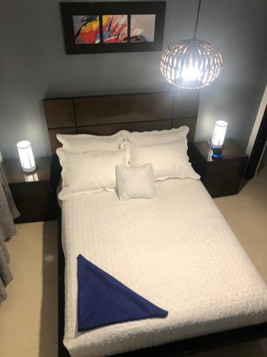 1 dormitorio con cama blanca y almohada azul en PREMIER APARTMENT., en Cúcuta
