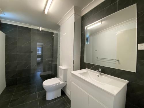 a bathroom with a white toilet and a sink at Residential two bedroom, self-contained, renovated apartment, Sheridan St, self check-in in Cairns