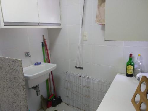 a small white bathroom with a sink and a toilet at Laguna Ville 08 in Itacimirim