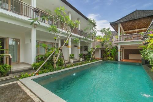 an image of a swimming pool in front of a building at Tri Dewi Residence by Pramana Villas in Ubud