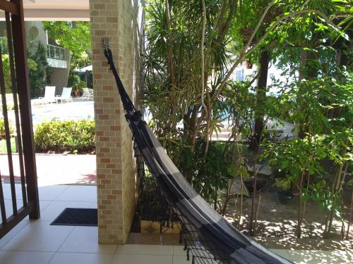 a hammock is tied to the side of a building at Laguna Ville 08 in Itacimirim