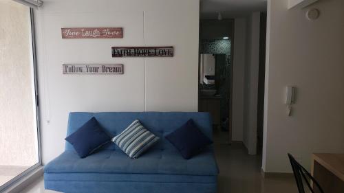 a blue couch in a living room with two pillows at Piscina & Descanso - Puerto Azul- con todas las comodidades! in Ricaurte