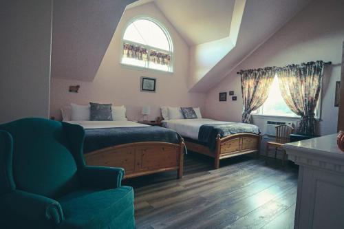 a bedroom with two beds and a chair and a window at Tucker Peak Lodge in Julian