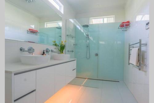 a bathroom with two sinks and a glass shower at Wandew - Echuca Holiday Homes in Echuca
