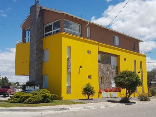 a yellow house on the side of a street at Complejo Bahia Ballenas in Rawson