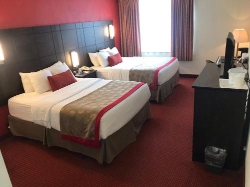 two beds in a hotel room with red walls at Ramada by Wyndham Ligonier in Ligonier