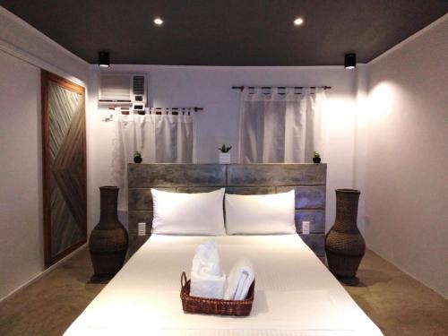 a bedroom with a bed with a basket of towels at PAYAG SUITES in General Luna