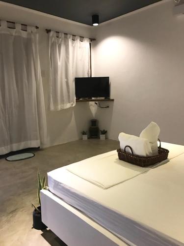 a room with a bed with a chair and a tv at PAYAG SUITES in General Luna