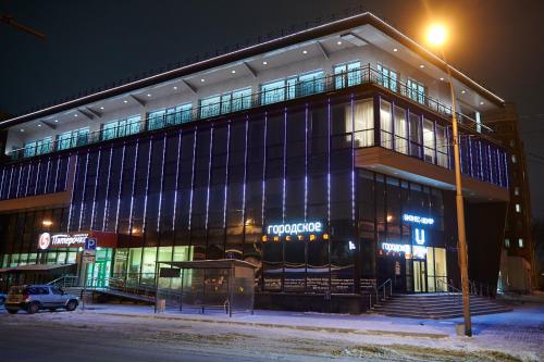 un edificio de noche con un estacionamiento delante de él en Urban Hotel en Omsk
