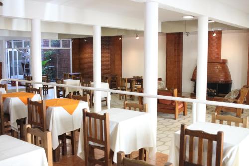 a dining room with white tables and chairs at Hotel Catedral San Rafael in San Rafael