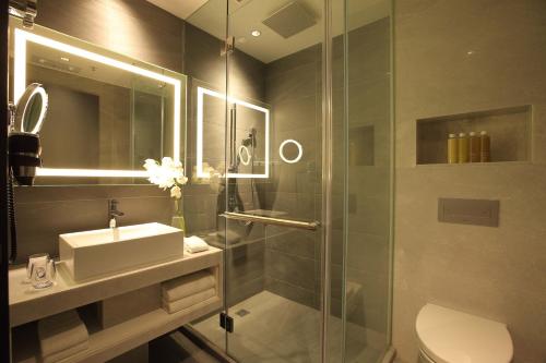 a bathroom with a shower and a sink and a toilet at The Perkin Hotel in Hong Kong