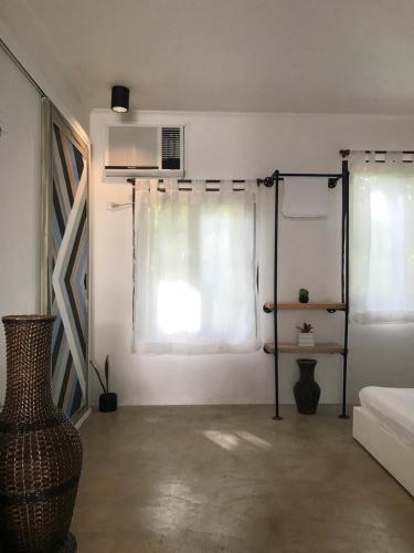 a room with a window and a bed and a fan at PAYAG SUITES in General Luna