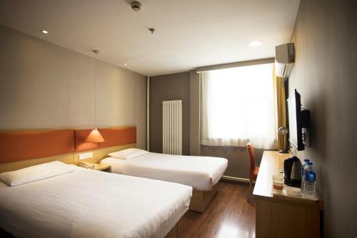 a hotel room with two beds and a television at Home Inn Xi'an South Taihua Road Daming Palace Relics Park in Xi'an