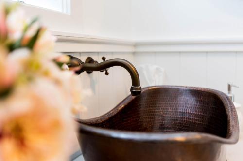 eine Kupferspüle mit einem Wasserhahn in der Küche in der Unterkunft Peria Hills Cottage in Matamata