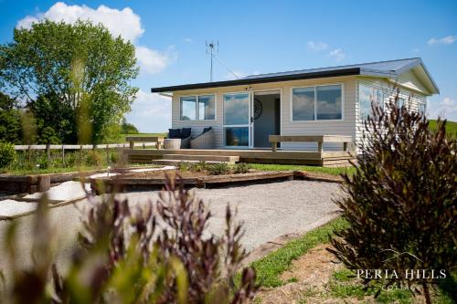a small house with a garden in front of it at Peria Hills Cottage in Matamata