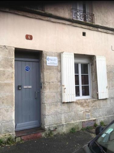 une porte bleue sur le côté d'un bâtiment dans l'établissement Le printemps de mélusine, à Niort