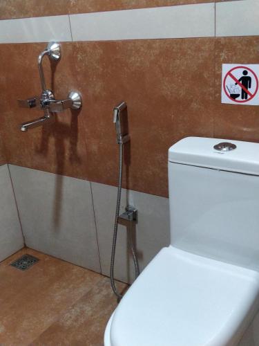 a white toilet in a bathroom with a shower at Majestic Inn in Trivandrum
