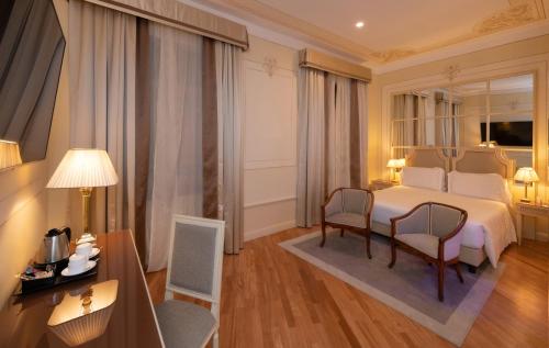 a hotel room with a bed and a table and chairs at Radisson Blu GHR Rome in Rome