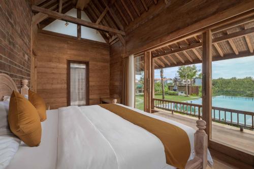 1 dormitorio con cama grande y ventana grande en Cahaya Villa Canggu By Island Escape en Canggu