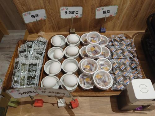 a wooden table with a box of chocolates and plates at Green Rich Hotel Miyazaki Tachibandori 2 (Artificial hot spring Futamata Yunohana) in Miyazaki