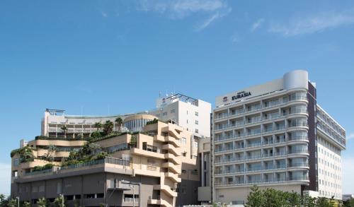 un grand bâtiment avec des arbres au-dessus dans l'établissement SPA&HOTEL EURASIA MAIHAMA, à Urayasu