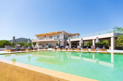 una piscina di fronte a una villa di 180 South Seaside Hotel a Thermisía