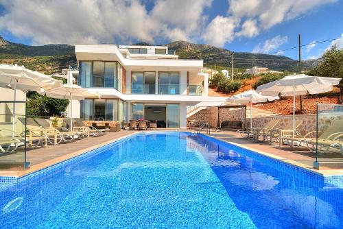 a villa with a swimming pool in front of a house at Villa Ahiska in Kalkan