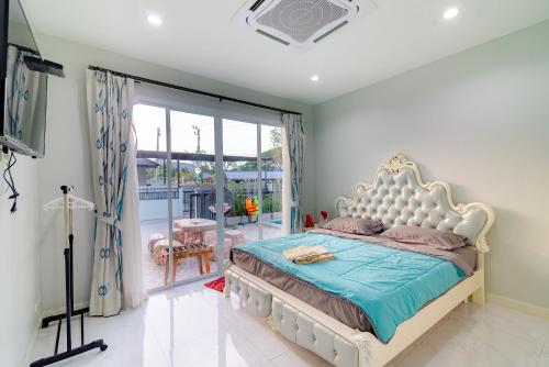 a bedroom with a large bed and a balcony at Smart home huahin in Hua Hin