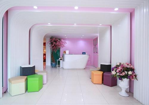 a room with brightly colored stools in a pink room at Pintree Pattaya in Pattaya South