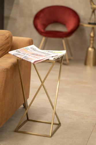 a table with a newspaper on it next to a couch at Club Meeting Hotel in Rimini