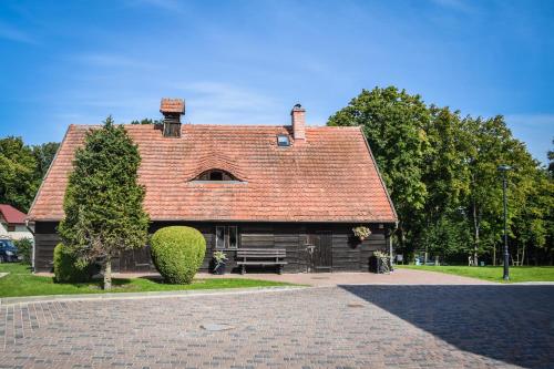 a house with a red roof on a brick road at Ośrodek Turystyczny Warzenko in Warzenko