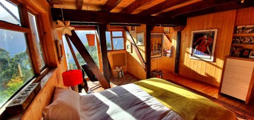 a bedroom with a bed in a room with windows at Cabin in da Woods in Cape Town