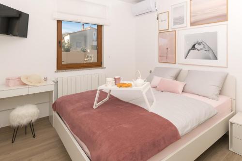 Schlafzimmer mit einem weißen Bett und einem Tisch in der Unterkunft Relaxing pool villa Mattuzzi in Loborika in Loborika